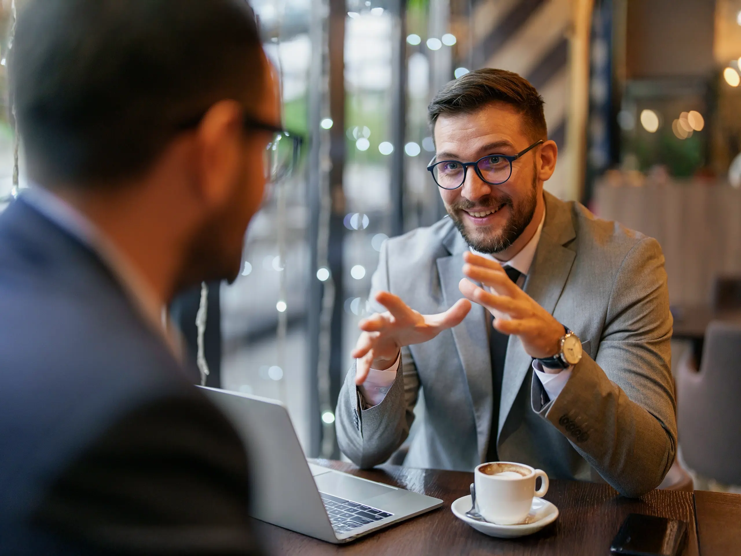 Two men at a table talking looking happy