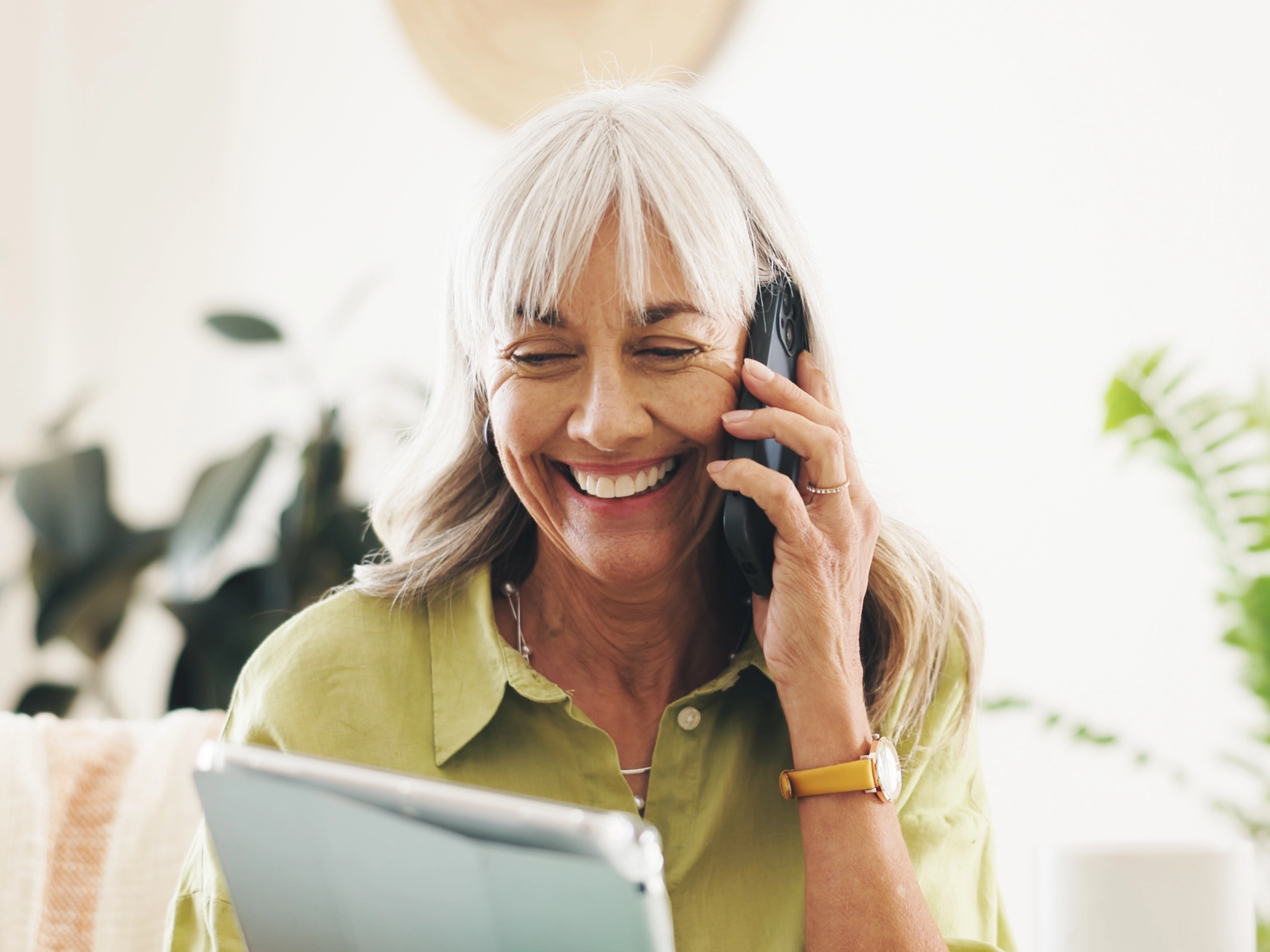 Mature businesswoman in office on the phone looking happy