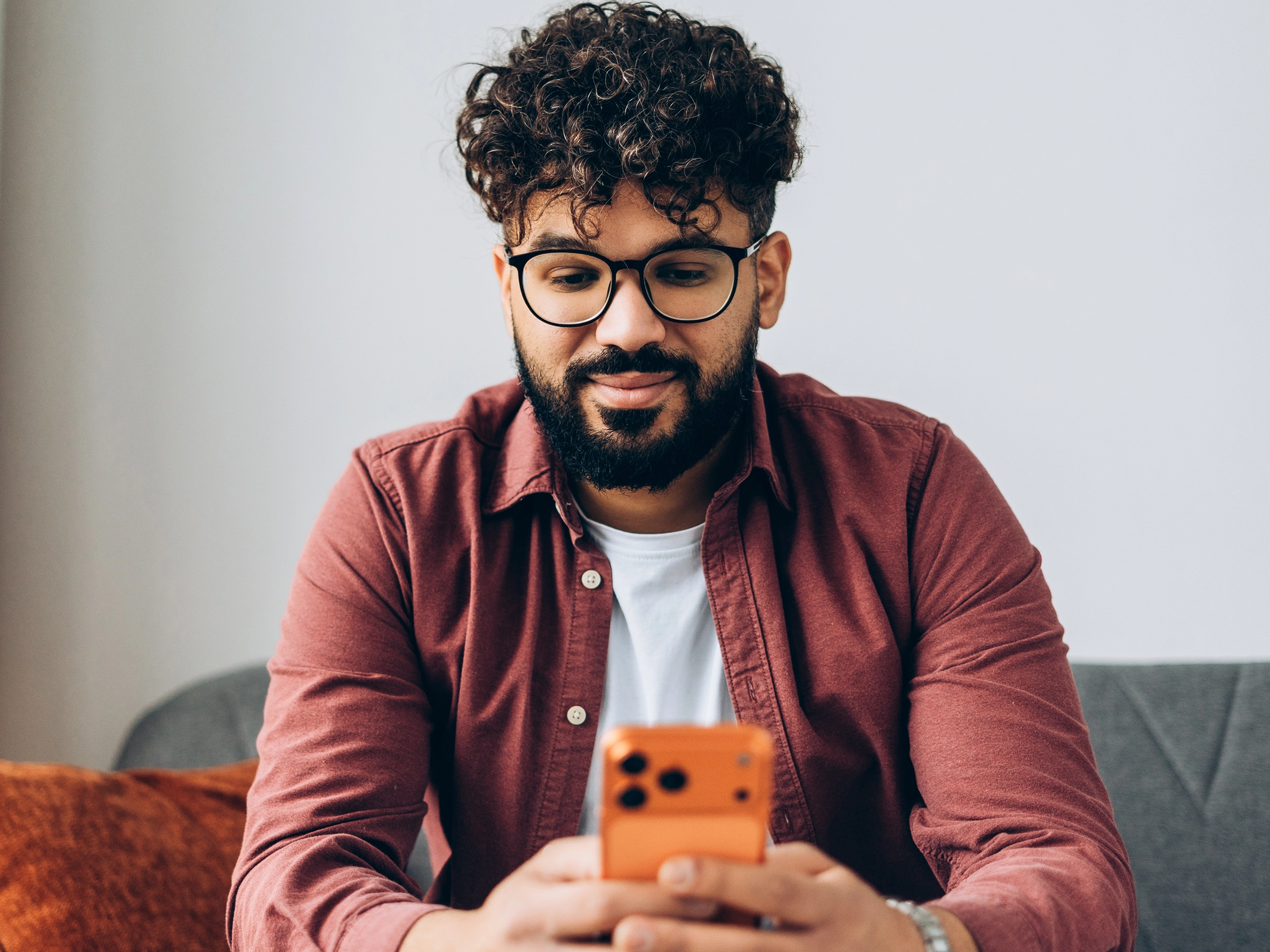 Young smiling middle eastern man using smartphone.