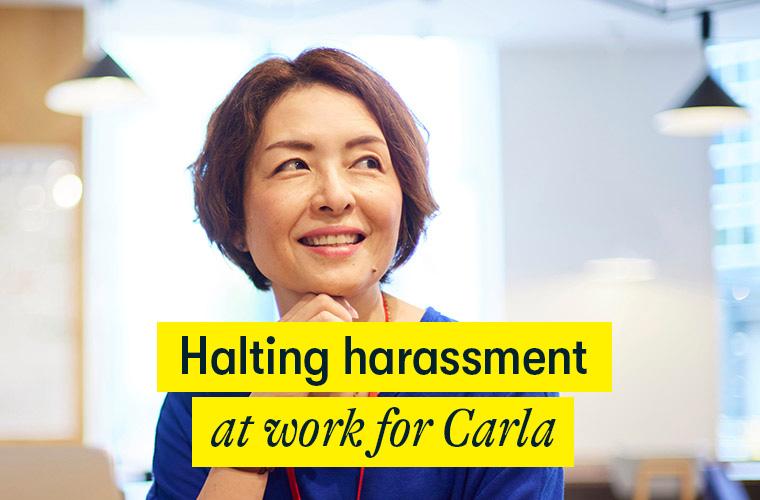 Halting harassment at work for Carla Halting harassment at work for Carla - a middle aged woman sits in an office looking happy